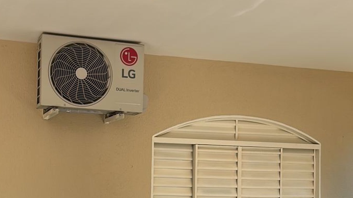 Unidade condensadora LG instalada e fixada na parede de uma residência, com suporte nivelado
